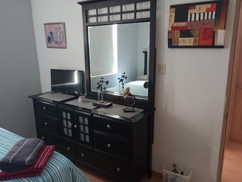 sypialnia z komodą z lustrem i łóżkiem w obiekcie Rincon Soberano Residencial w mieście Chihuahua