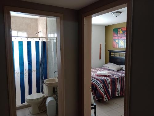 sypialnia z łóżkiem oraz łazienka z toaletą w obiekcie Rincon Soberano Residencial w mieście Chihuahua