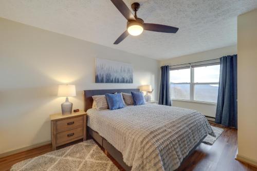 a bedroom with a bed with a ceiling fan and a window at Lovely Beech Mountain Condo with Balcony and Views! in Beech Mountain