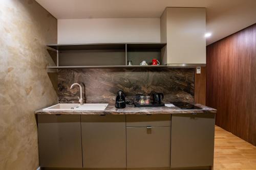 a kitchen with a sink and a counter top at ATLAS Hotel in Timişoara