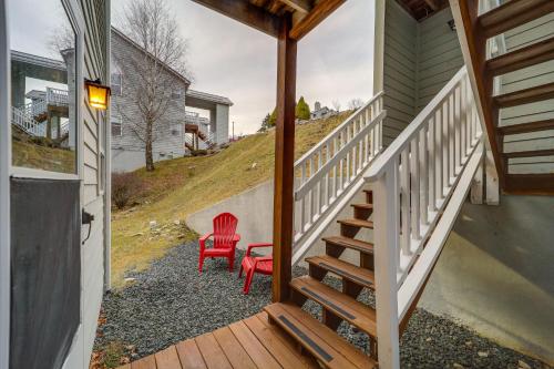 a porch with a red chair and a stair case at Lovely Beech Mountain Condo with Balcony and Views! in Beech Mountain
