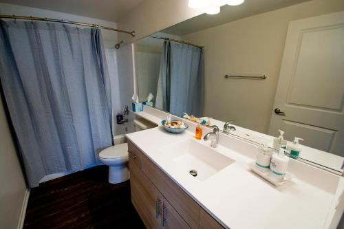 a bathroom with a sink and a toilet and a mirror at Bay Views & Gaslamp/Little Italy/Convention 1BD in San Diego