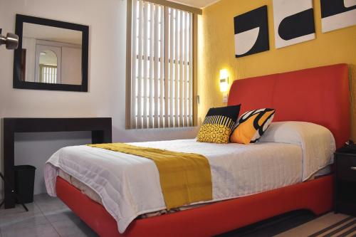 a bedroom with a bed with a red and yellow headboard at Alojamiento cómodo: Casa ideal in Morelia