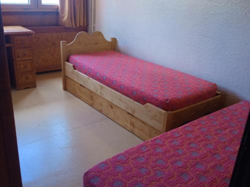 Appartement La Plagne, 3 pièces, 8 personnes - FR-1-181-2665 في La Plagne Tarentaise: سريرين في غرفة مع مرتبة حمراء