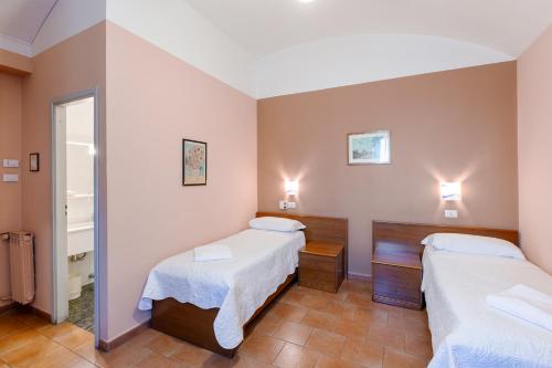 a room with two beds and a mirror at Hotel Castello in Turin