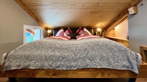 a bedroom with a large bed with red pillows at Berggasthaus Eggberge - Boutique Mountain Hotel - Access via Cablecar in Altdorf