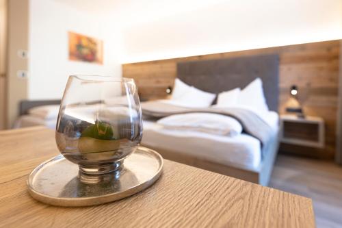 a wine glass sitting on a table in a hotel room at Hotel Thuinerwaldele in Vipiteno