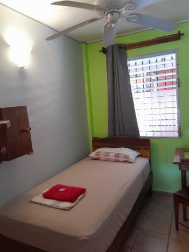 a bedroom with a bed with a red towel on it at Hostal Hansi in Bocas del Toro