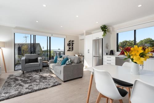 a kitchen and living room with a table and chairs at Luxury Apartment retreat in Tauranga
