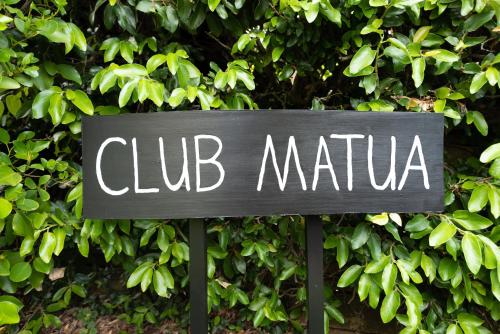 a sign that reads club marina in front of a bush at Luxury Apartment retreat in Tauranga