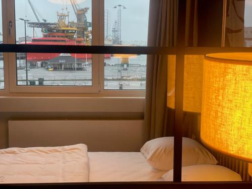 een slaapkamer met een bed en een raam met uitzicht bij Apartments by Jutlandia in Frederikshavn
