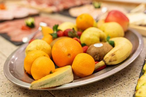 a plate filled with fruit on a table at Hotel Thuinerwaldele in Vipiteno