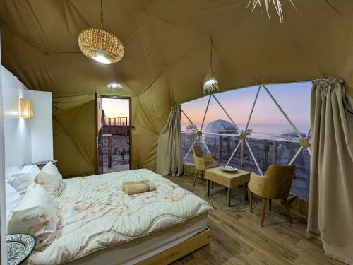 a bedroom with a bed in a tent with a view at Timlalin Dome in Tamri