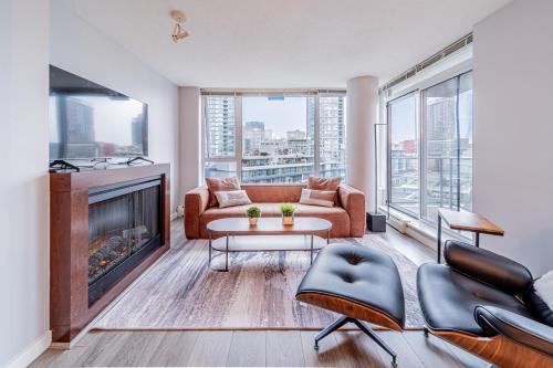 a living room with a couch and a fireplace at Near BC Place & SkyTrain Access & Free Parking in Vancouver
