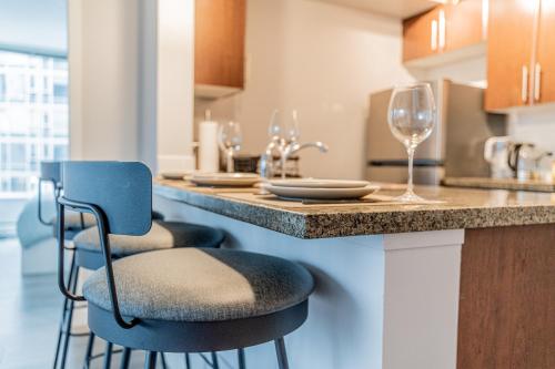 a kitchen with a counter with two chairs and wine glasses at Amazing Views ! Leather Furniture ! Cozy Condo! in Vancouver