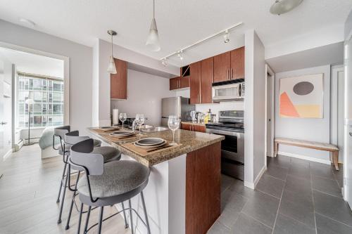 a kitchen with a counter and bar stools at Near BC Place & SkyTrain Access & Free Parking in Vancouver