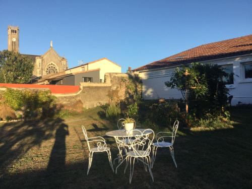 un tavolo e sedie nel cortile di una casa di Charmante Maison avec Jardin, Proche Puy du Fou et Cholet, Wifi, Tout Confort - FR-1-622-48 a Les Gardes