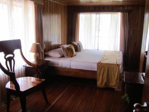 a bedroom with a bed and a chair and a window at Hotel Victoria in El Castillo de La Concepción