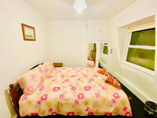 - une chambre avec un lit et une couverture fleurie dans l'établissement Two Bedroom Property in Central London, à Londres