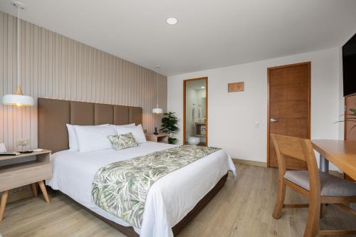 Un pat sau paturi într-o cameră la Affinity Aparta Hotel