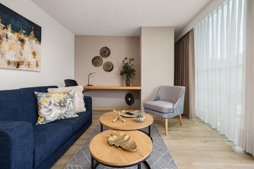 a living room with a blue couch and a table at Affinity ApartaHotel in Medellín