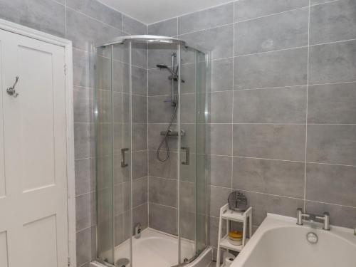a bathroom with a shower with a tub and a sink at Mimosa in Dawlish