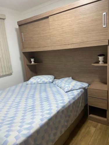 um quarto com uma cama grande e uma cabeceira em madeira em Apartamento Mari 4 em São Carlos
