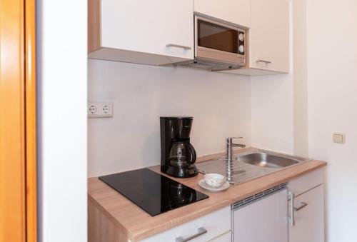 uma cozinha com um lavatório e comodidades para preparar café em Aschau-Apartments em Aschau im Chiemgau