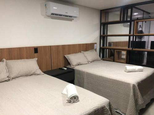 a room with two beds with a dog laying on the bed at Get One - Bessa in Tambaú