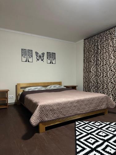 ein Schlafzimmer mit einem Bett und zwei Schmetterlingen an der Wand in der Unterkunft HOTEL BOBROvski in Jassinja