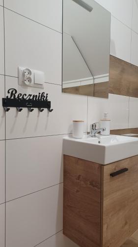 a bathroom with a sink and a mirror at Dom Ci Spokój in Czudec