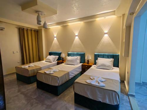 two beds in a room with two tables at Grand Egyptian Museum View Inn in Cairo