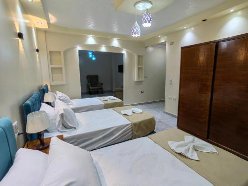 a hotel room with three beds in a room at Grand Egyptian Museum View Inn in Cairo