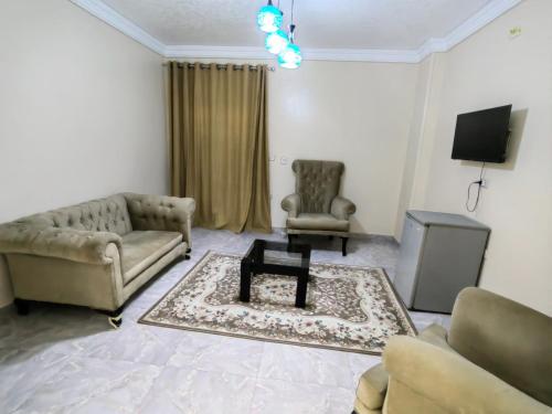 a living room with a couch and two chairs and a table at Grand Egyptian Museum View Inn in Cairo