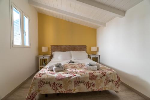 a bedroom with a bed and two windows at CapoSud - Appartamento Sottovento in Marina di Ragusa