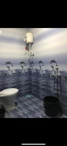 a bathroom with a flock of birds on the wall at Vickys Guest House in Malvan