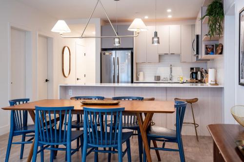 a kitchen with a wooden table and blue chairs at Powder Pines Retreat by Revelstoke Vacations in Revelstoke