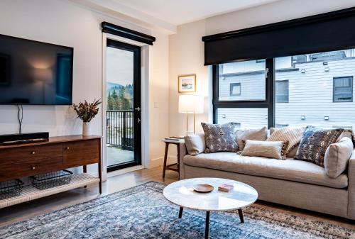 a living room with a couch and a tv at Powder Pines Retreat by Revelstoke Vacations in Revelstoke