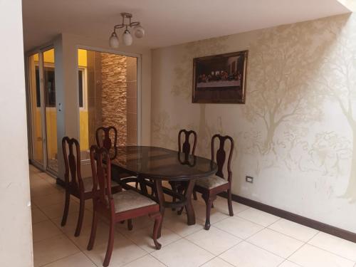 a dining room with a wooden table and chairs at Villas de San Jose 3 in Mixco