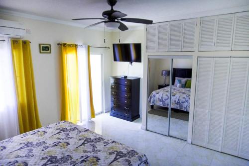 a bedroom with a bed and a mirror and a ceiling fan at palmview estate townhouse in Mammee Bay