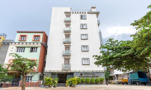 a white building with trees in front of it at Treebo Fortune Gateway in Bangalore