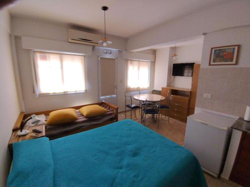 a bedroom with a blue bed and a table at Center Studio pax 3 apartamento in Trelew