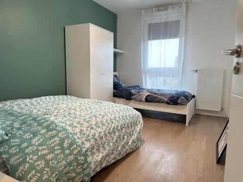 Schlafzimmer mit einem Bett und einem Fenster in der Unterkunft Agréable 3 pièces avec Parking à La Courneuve Gare by immo Kit bnb in La Courneuve