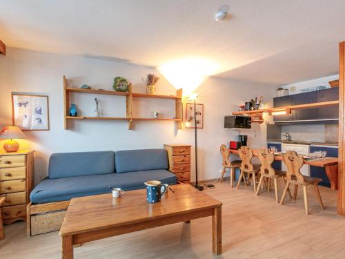un salon avec un canapé bleu et une table dans l'établissement Appartement cosy à La Daille, skis aux pieds, WiFi, animaux acceptés - FR-1-694-192, à Val dʼIsère