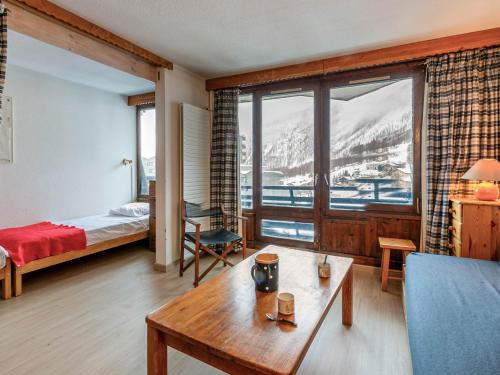 une chambre avec un lit, une table et une fenêtre dans l'établissement Appartement cosy à La Daille, skis aux pieds, WiFi, animaux acceptés - FR-1-694-192, à Val dʼIsère
