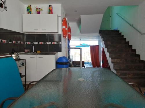 uma cozinha com uma mesa de vidro e uma escada em Mollendo em Mollendo