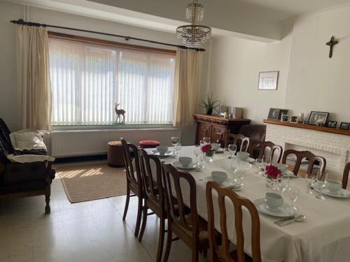 a dining room with a table and chairs and a room with at Vakantiewoning Wurfeldermolen in Maaseik