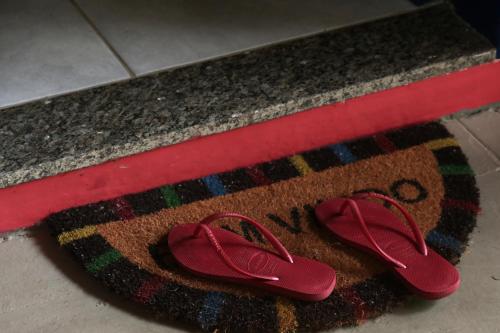a pair of red shoes sitting on a rug at Casa Matatiso - casa na Ilha Grande para até 6 pessoas in Angra dos Reis