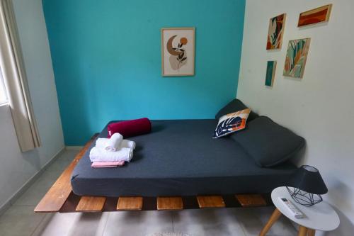a room with a bed with a blue wall at Casa Matatiso - casa na Ilha Grande para até 6 pessoas in Angra dos Reis