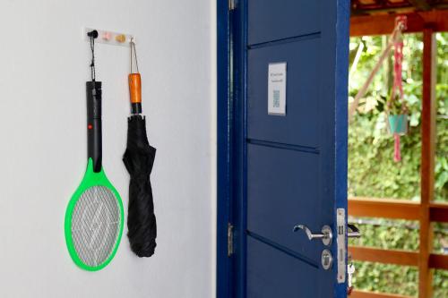 a tennis racket and an umbrella hanging next to a door at Casa Matatiso - casa na Ilha Grande para até 6 pessoas in Angra dos Reis